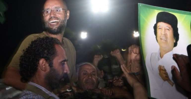 Seif al-Islam Kadhafi, son of Libyan leader Moamer Kadhafi, is surrounded by supporters in Tripoli in 2011. By Imed Lamloum (AFP/POOL/File)