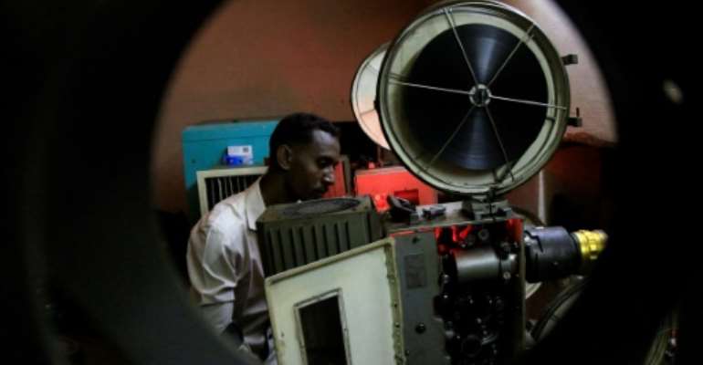 In this picture from 2014, a Sudanese man prepares a film for projection at The Palace of Youth and Children, one of just three functioning cinemas left in the area around the capital Khartoum at the time. By ASHRAF SHAZLY (AFP/File)