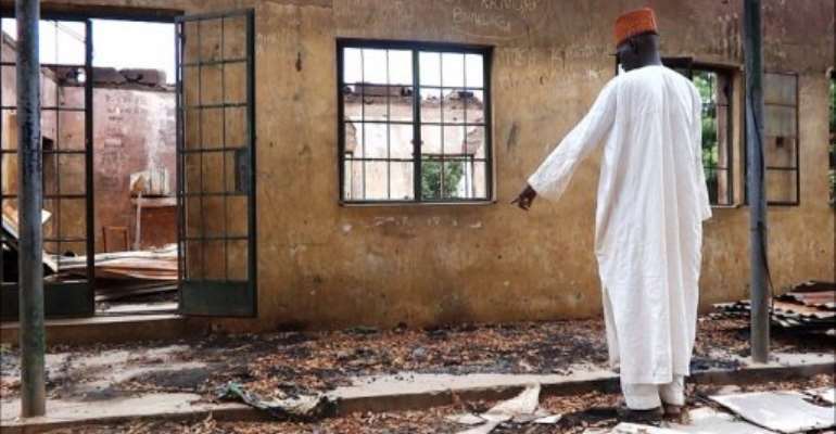 A man inspects a burnt student hostel in the northeast Nigerian Yobe state on August 6, 2013.. By Aminu Abubakar (AFP/File)