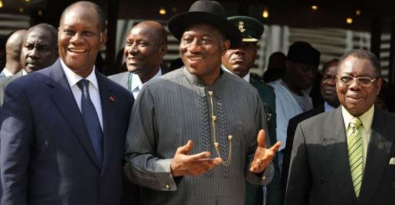 Outgoing chairman Nigerian President Goodluck Jonathan (C) passes the torch to Ivorian President Alassane Ouattara (L). By Pius Utomi Ekpei (AFP)