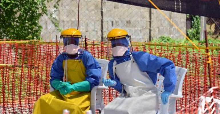 Health workers sit at Medecins Sans Frontieres' Ebola treatment center inside the Samuel K. Doe stadium in Monrovia on October 15, 2014. By Zoom Dosso (AFP/File)