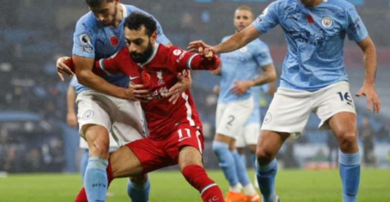 Liverpool forward Mohamed Salah (C) battles for possession against Manchester City in the English Premier League. By Clive Brunskill (POOL/AFP)
