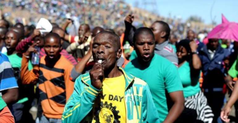 Co-workers of 34 miners shot dead by police during a strike gather on August 16, 2013 in Marikana to mark their deaths. By Stephane de Sakutin (AFP)