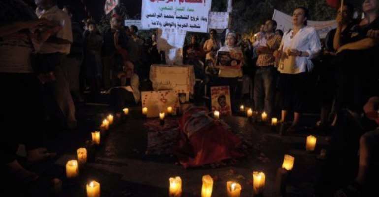 Tunisian protesters light candles by a symbolic coffin on August 4, 2013 in Tunis. By Fethi Belaid (AFP/File)