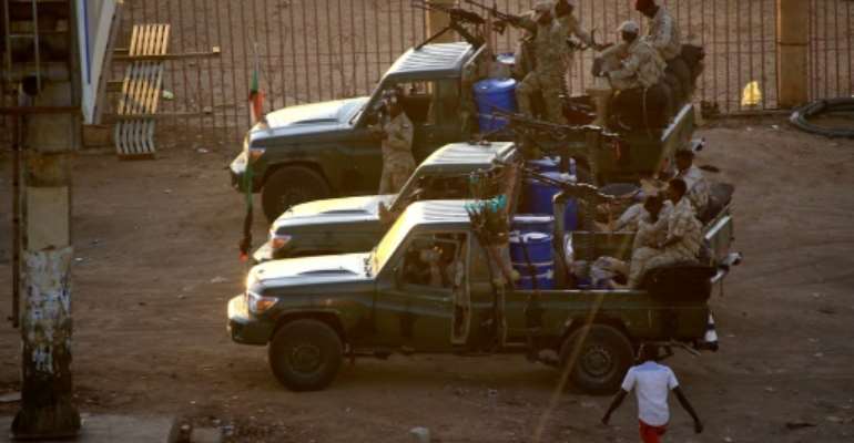 Members of Sudan's intelligence services shoot bullets in the air at the headquarters of the Directorate of General Intelligence Service in the Riyadh district of the capital Khartoum. By ASHRAF SHAZLY (AFP)