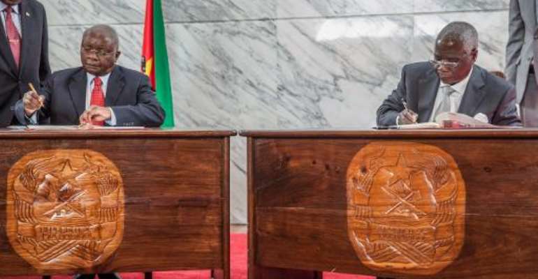 Mozambican President, Armando Guebuza (L) and rebel Renamo leader Afonso Dhlakama sign a peace deal on September 5, 2014 at the Presidential palace in Maputo, to end almost two years of armed conflict.  By Jinty Jackson (AFP)