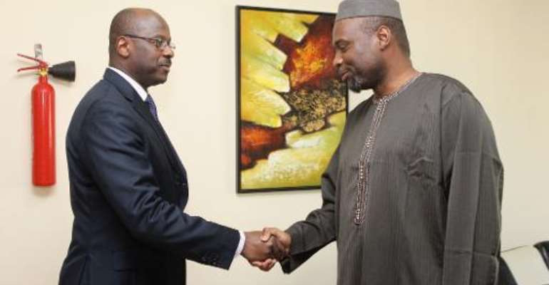 Outgoing Malian prime minister Oumar Tatam Ly (L) shakes hands with his successor Moussa Mara during a handover ceremony in Bamako on April 9, 2014. By Habibou Kouyate (AFP/File)