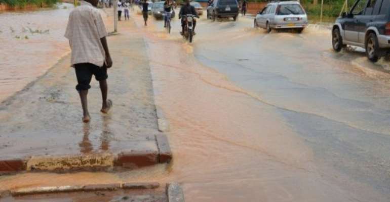 Vehicles use a flood-water covered road near the Niamey river in Niamey on August 21, 2012. By Boureima Hama (AFP/File)