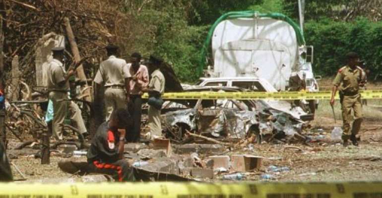 Tanzanian policemen check debris near the US embassy building after a bomb exploded in Dar es Salaam on August 8, 1998. By Amr Nabil (AFP/File)