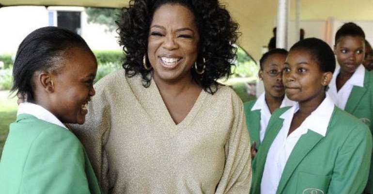 Oprah Winfrey with students of the first graduating class at her South African girls' academy in Henley on Klip. By STEPHANE DE SAKUTIN (AFP)