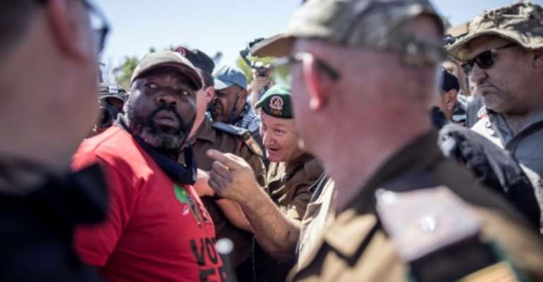 Outside the courthouse during a hearing of the murder suspects groups of whites and blacks faced off. By MARCO LONGARI (AFP)
