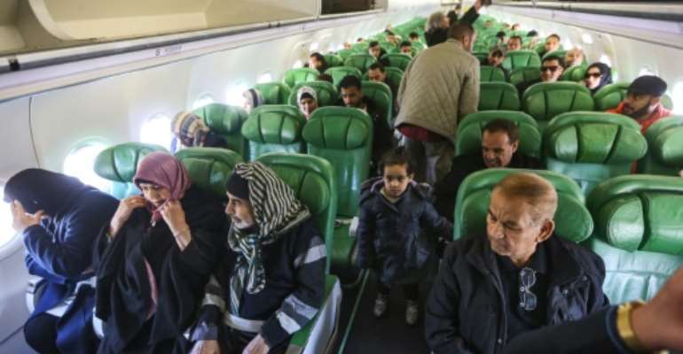 Passengers board and sit inside an aircraft at Mitiga airport, east of the Libyan capital Tripoli. By Mahmud TURKIA (AFP)