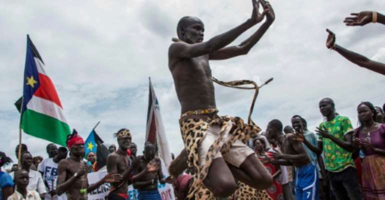 People celebrate as they wait for the arrival of South Sudan's President Salva Kiir in the capital Juba on August 6, 2018, following the signing in neighbouring Sudan of a ceasefire and power sharing agreement. By AKUOT CHOL (AFP)
