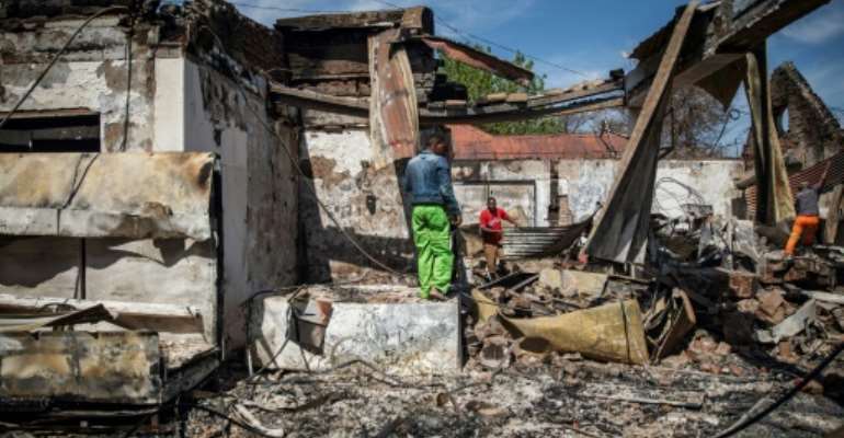 People rummage through looted foreign-owned shops in Malvern, a Johannesburg suburb. By Michele Spatari (AFP)