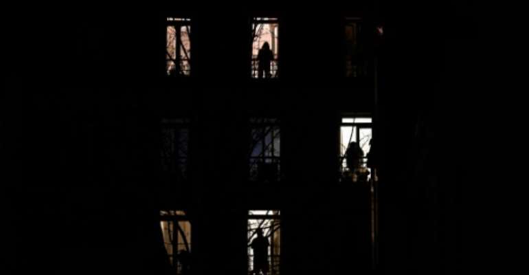 People stand by their windows and applause in solidarity with healthcare workers on the frontline of the coronavirus outbreak in Paris in March. By PHILIPPE LOPEZ (AFP/File)