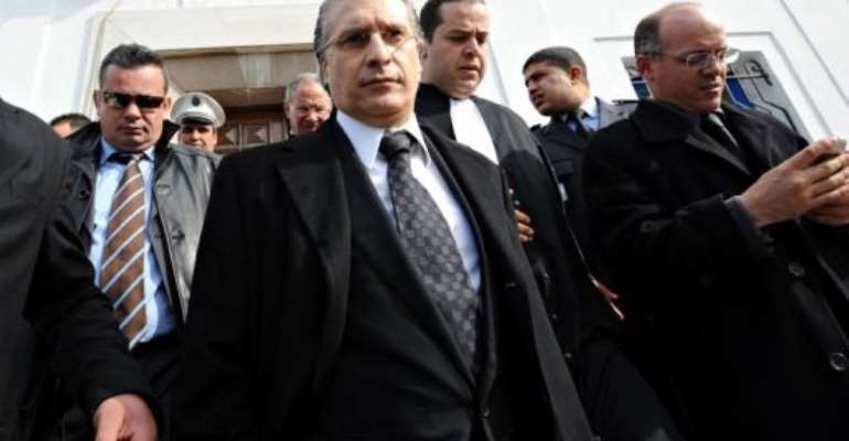 The director of the Tunisian private TV channel Nessma television, Nabil Karoui (C), leaves the courthouse in Tunis. By Fethi Belaid (AFP)