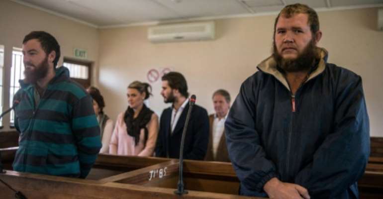 Pieter Doorewaard (L) and Philip Schutte, pictured May 2017, were found to have killed Matlhomola Mosweu, a black teen, after claiming they caught him in the act of taking a plant from a farm. By MUJAHID SAFODIEN (AFP/File)