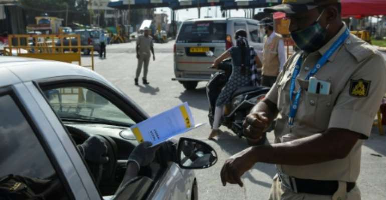 Police stop people travelling to Bangalore and direct them to undergo coronavirus screening. By Manjunath Kiran (AFP)
