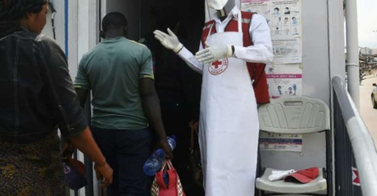 Precautions: Travellers crossing between Uganda and DR Congo were screened for high temperatures and told to disinfect their hands. By ISAAC KASAMANI (AFP)