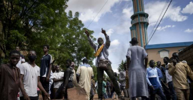 Protesters at a barricade erected in front of the Salam Mosque in Bamako, where Imam Mahmoud Dicko, a leader of the anti-government movement, led prayers on Sunday for victims of the clashes. By MICHELE CATTANI (AFP)
