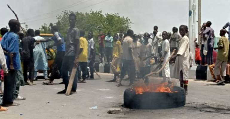 Protesters block a main road in the northern Nigerian city of Maiduguri, demanding the authorities ban a local anti-Boko Haram militia they say is abusing them. By Audu MARTE (AFP)