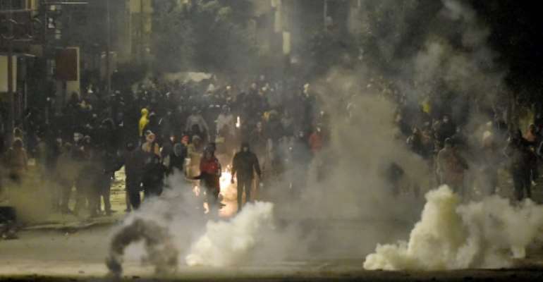 Protesters clash with security forces in the Ettadhamen suburb of Tunis on Monday night. By FETHI BELAID (AFP)
