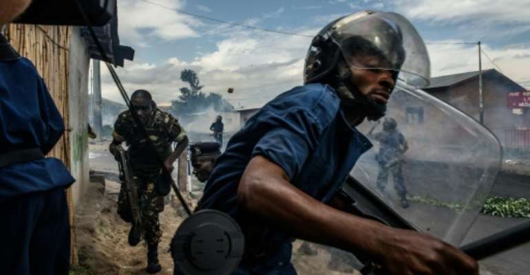 Protesters throw stones at a police officer after President Pierre Nkurunziza announced a third presidential bid in 2015. By Jennifer Huxta (AFP/File)