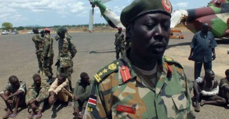 South Sudan soldiers guard a group of Sudanese prisoners of war in Juba on Sunday. By Waakhe Wudu (AFP/File)