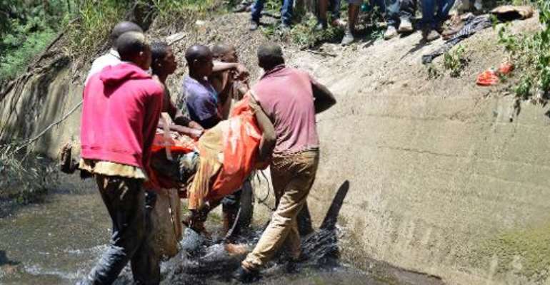 The body of an illegal miner is carried after being pulled out of an illegal gold mine in Benoni, outside Johannesburg, on February 18, 2014. By Mujahid Safodien (AFP)
