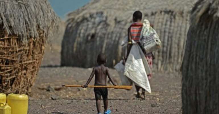 A mother and child walk in the village of Komote on the shores of Lake Turkana, northern Kenya on May 18, 2012. By Carl de Souza (AFP/File)