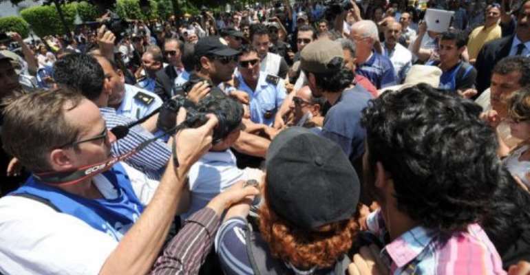 Demonstrators and police clash on Habib Bourguiba avenue in Tunis. By Fethi Belaid (AFP)