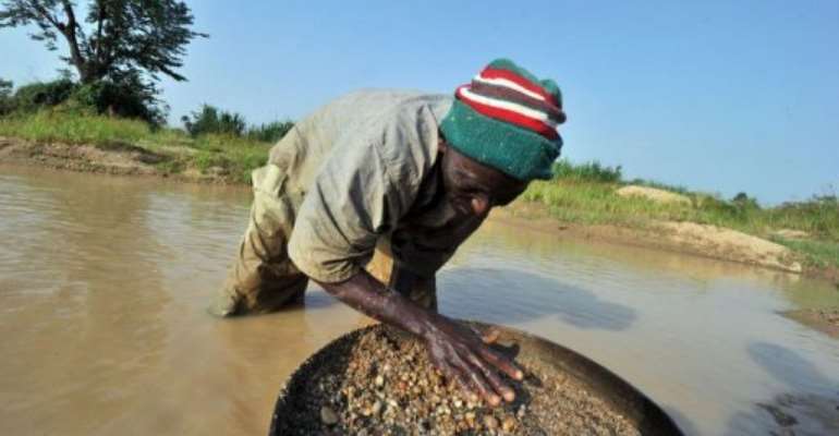 A diamond prospector filters earth from a river in April in Koidu. By Issouf Sanogo (AFP/File)