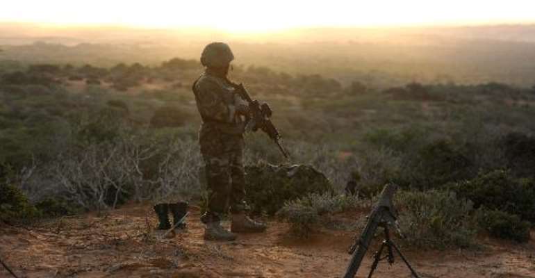 Handout image made by the African Union Mission to Somalia on October 6, 2014, shows a soldier belonging to the African Union Mission in Somalia, standing on the top of a hill next to the al-Shabab stronghold of Barawe. By Tobin Jones (AMISOM/AFP/File)