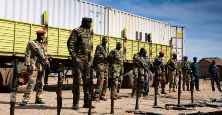 South Sudanese security forces stand next to weapons intercepted from a UN peacekeeping mission in Rumbek on March 8, 2014. By Charles Lomodong (AFP)