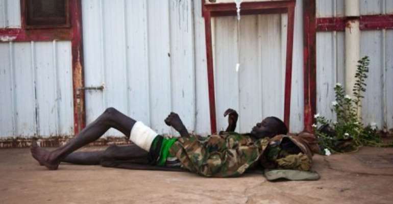 A wounded soldier of the South-Sudan's Sudan People's Liberation Army (SPLA) rests outside the Rubkona Military Hospital. By Adriane Ohanesian (AFP)
