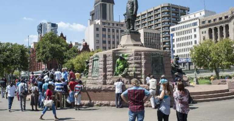 People visit the defaced statue of Paul Kruger in Church Square, Pretoria on April 6, 2015. By Stefan Heunis (AFP)