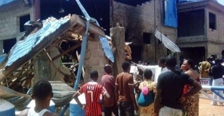 Bystanders look at the Sharon Church after it was struck by a suicide bomber in Kaduna on June 17. By Victor Ulasi (AFP)