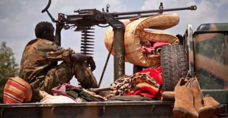 A SPLA soldier sits next toe a machine gun on a vehicle outside an old Sudan Armed Forces compound in Heglig. By Adriane Ohanesian (AFP)