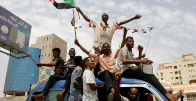 Sudanese celebrate a hard-won deal between protest leaders and the country's ruling generals aimed at turning the page on months of political unrest. By ASHRAF SHAZLY (AFP)
