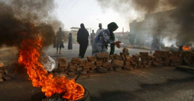 Sudanese protesters close Street 60 with burning tyres and pavers as military forces tried to disperse a sit-in outside Khartoum's army headquarters on June 3, 2019.At least two people were killed Monday as Sudan's military council tried to break up a sit-in outside Khartoum's army headquarters, a doctors' committee said as gunfire was heard from the protest site. By ASHRAF SHAZLY (AFP)