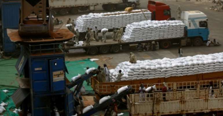 Sudanese workers offload US aid destined for South Sudan from the World Food Programme (WFP) at Port Sudan. By ASHRAF SHAZLY (AFP/File)
