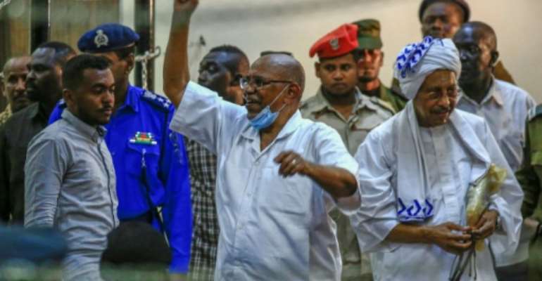 Sudan's ousted president Omar al-Bashir (C) gestures on arrival for his trial in the capital Khartoum along with 27 co-accused over the 1989 military coup that brought him to power. By ASHRAF SHAZLY (AFP)