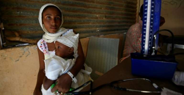 Tens of thousands of Ethiopians have fled fighting into neighbouring Sudan -- here a mother receives medical care at the Um Raquba refugee camp. By ASHRAF SHAZLY (AFP)