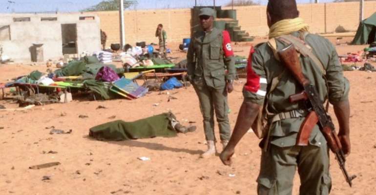 The body of a dead soldier is covered with a blanket after a suicide bomb attack ripped through a camp of former rebels and pro-government militia in northern Mali on January 18, 2017. By (AFP)
