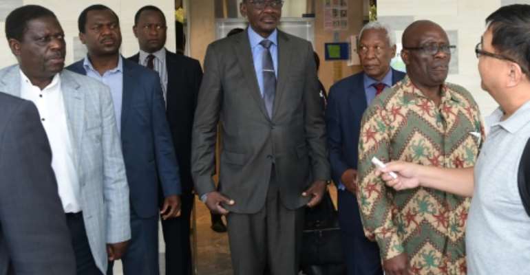 The group, including Vice President Kembo Mohadi (C), attended a private Catholic mass for Mugabe officiated by a Zimbabwean priest. By ROSLAN RAHMAN (AFP)