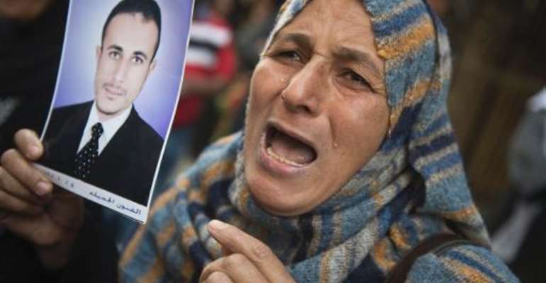 An Egyptian woman holding the portrait of a relative reacts outisde the court that sentenced 682 alleged Islamists and a Muslim Brotherhood leader to death on April 28, 2014 in the southern city of Minya. By Khaled Desouki (AFP)