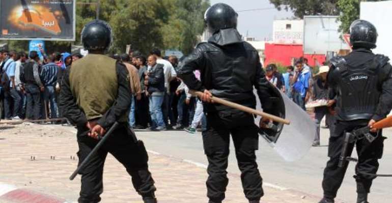 Tunisian riot police face residents of the southeastern town of Ben Guerdane during a general strike on April 2, 2014. By Jawad Nasri (AFP/File)