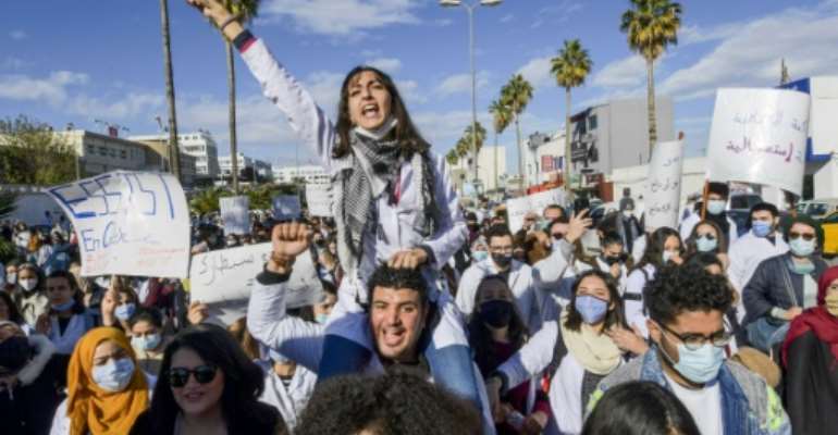 Tunisian doctors demonstrate in the capital Tunis over the country's crumbling public health infrastructure, following the death of a young doctor in a lift accident. By FETHI BELAID (AFP)