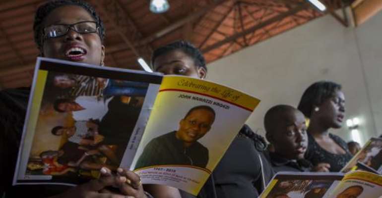 Children of the late acting assistant director of public prosecution Joan Kagezi attend a church service for their mother on April 2, 2015 in Kampala. By Isaac Kasamani (AFP)
