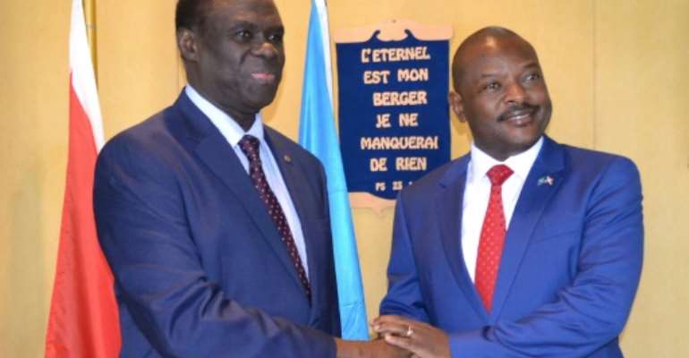 UN envoy to Burundi Michel Kafondo (L) shakes hands with Burundi's President Pierre Nkurunziza ahead of a meeting in June 2017. By STR (AFP/File)